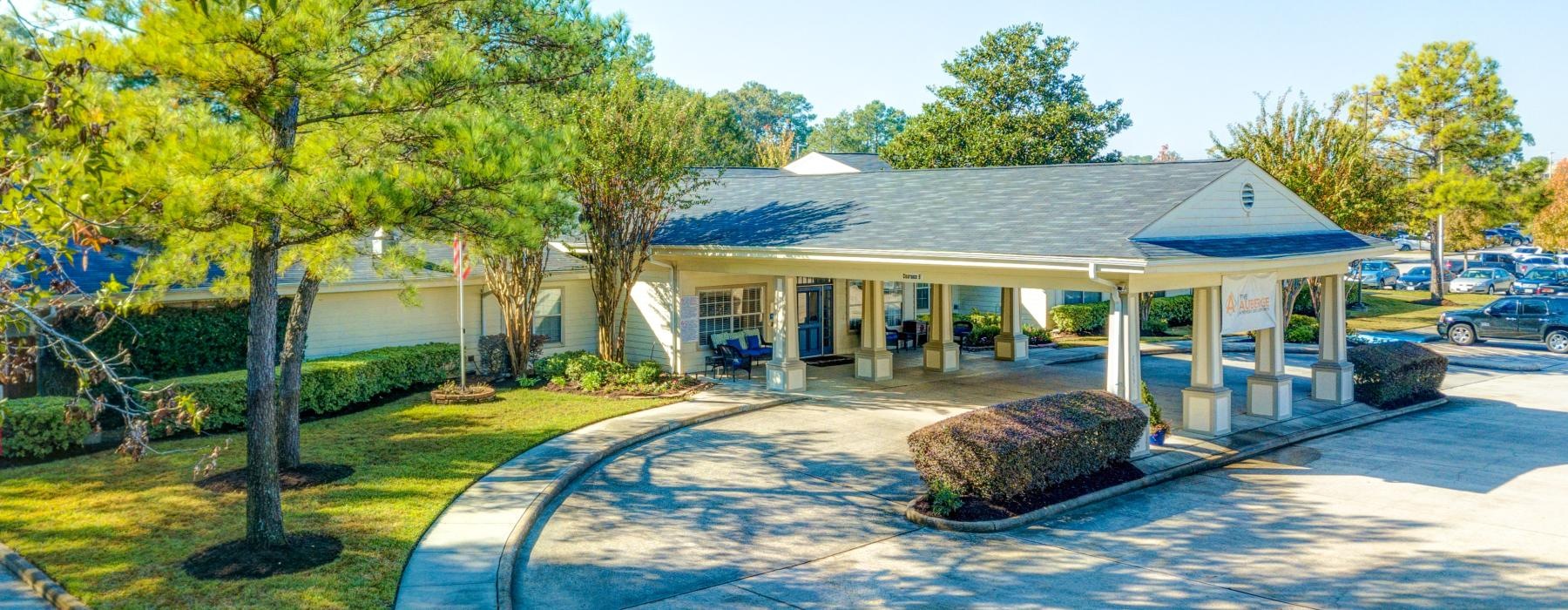 a clubhouse with landscaping and trees